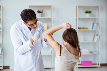 Doctor examining the skin of female patient