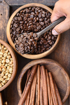 Close up of coffee beans in wooden bowl and cinnamon