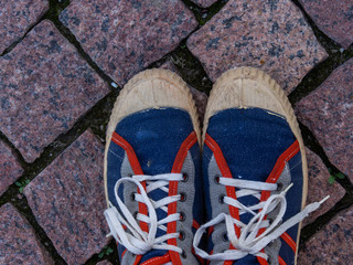 Vintage sports shoes, view from the edge. Sports background. Snowflakes on the pavement.