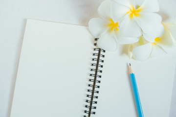 Sky color pencil on open white paper note book for writing.