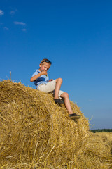 Naklejka na ściany i meble haystack sitting boy