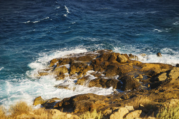 Sea waves break down on rocks and large stones.