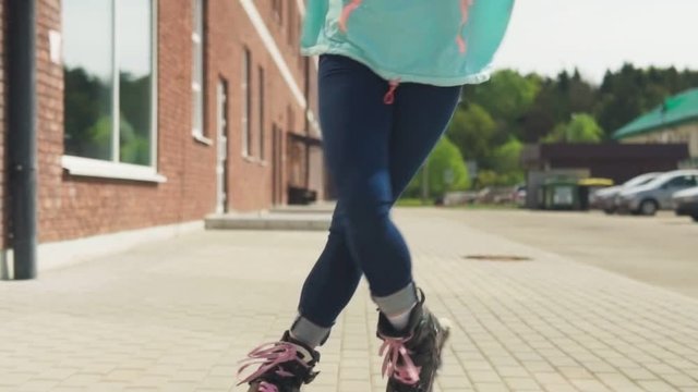 Young woman eenjoys rollerblading on a city street