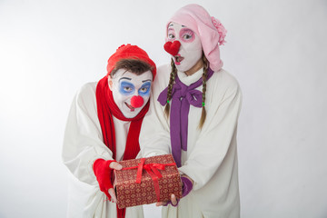 emotional mime guy and girl holding a gift. Human emotions: greed, joy and curiosity