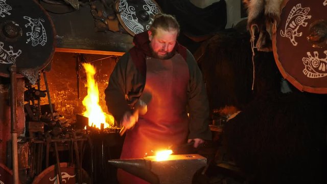 The smith viking working hard in a smithy