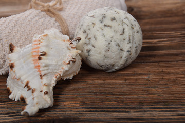 scallop and herbal white bath ball for white towel on a brown background