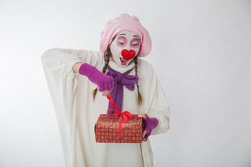emotional mime girl holding a gift. Human emotions: joy and curiosity
