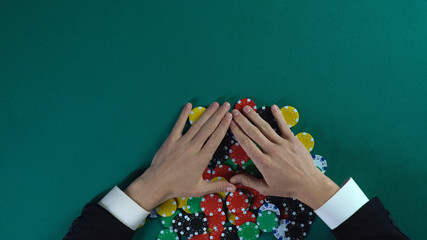 Winner rejoicing to all chips after poker game, greedy man taking all money