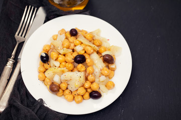 cod fish with chick pea and olives on dish
