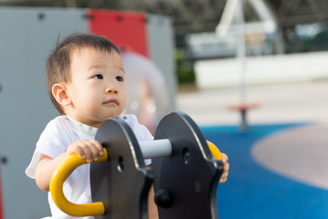 Adorable little Asian baby boy having fun on playground