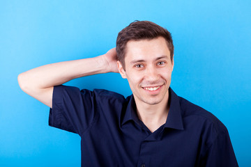 Handsome man in casual shirt on blue background in studio photo