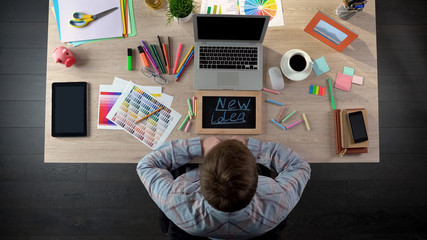 Top view of man writing new idea on blackboard, inspired for startup business