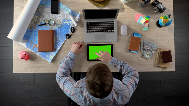 Man looking for interesting apps on tablet with green screen, digital world