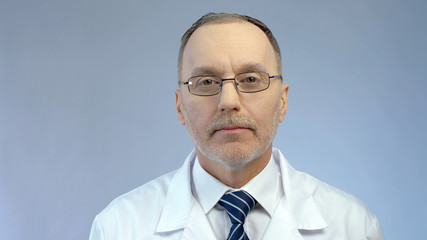Experienced look of serious male physician, professional medical aid at clinic