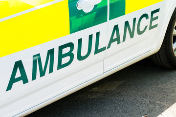 Elevated, angled view of Ambulance sign on the side of emergency response vehicle.