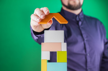 Businessman building tower of colorful wooden blocks