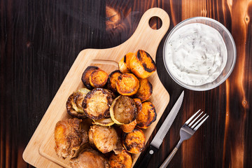 Fried chicken meat and grilled vegetables on wooden table