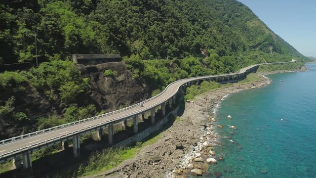 Aerial view of Patapat viaduct in the coast of Pagudpud, Ilocos Norte. Highway with bridge by coast sea near the mountains. Philippines, Luzon.