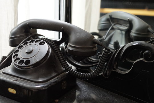 Old retro telephone behind mirror