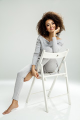 Beautiful black woman sitting on chair and smiling