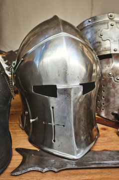 Shiny metal helmets of medieval knights with traditional weapons at a middle age theme festival