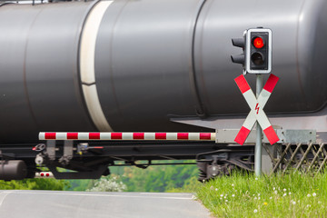 closed railroad crossing with passing cargo train