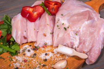 Fresh raw veal meat with spice and vegetables on wooden background