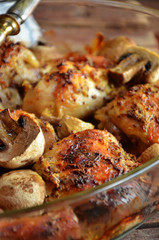 Baked chicken legs with mushrooms in glass roasting pan