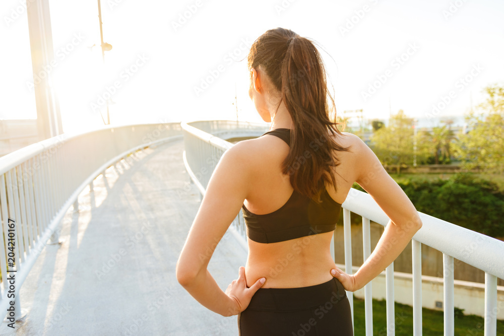 Wall mural Back view picture of amazing young asian sports woman