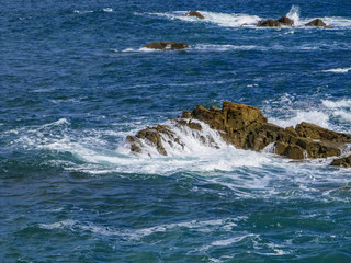Beautiful rocks at beach with waves and blue water