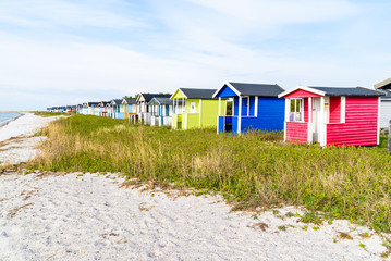 Fototapeta na wymiar Skanor, Sweden - Long row of colorful bathing sheds along the sandy beach