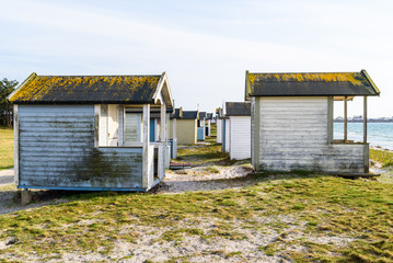 Fototapeta na wymiar Skanor, Sweden - Dirty and weathered bathing sheds along the coast.