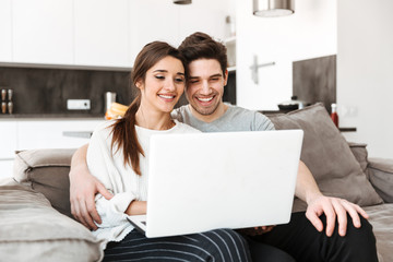 Portrait of a happy young couple using laptop computer
