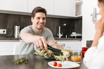 Fototapeta na wymiar Portrait of a happy young man having healthy breakfast