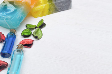 Spa concept background with copy space. Handmade solid soap and blue essential oil on white wooden table background.