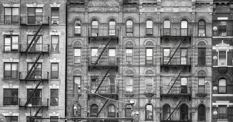 Fototapeten Schwarz-Weiß-Bild von alten Gebäuden mit Feuerleitern, eines der Symbole von New York City, USA. © MaciejBledowski