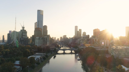 Fototapeta na wymiar AERIAL. Scenery sunset in Melbourne downtown, above Yarra river