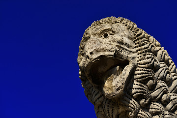 Ancient medieval lion statue, in the the Lucca old walls public park (with copy space)