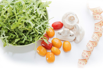 Health food. Fresh mushrooms and arugula salad, cherry tomatoes on light blue background. Diet meals.