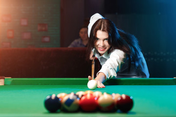 Young man and the woman play billiards