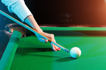 female hand close-up, billiards, player preparing to hit the ball. Pleasant pastime, entertainment,...