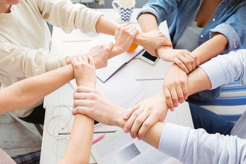 Obraz premium Nice picture of student's hands that areput together. They are a good team. Their hands made a circle.