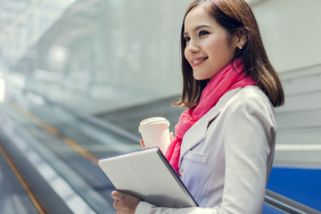 Fototapeta premium Business woman She is going to work in her morning at the subway. And she is eating coffee