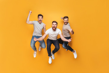 Three young happy men jumping together