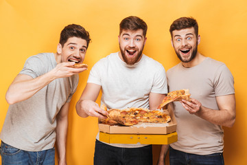 Three young happy men eating big pizza