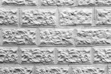 White wall made of decorative white blocks of uneven textured bricks. 