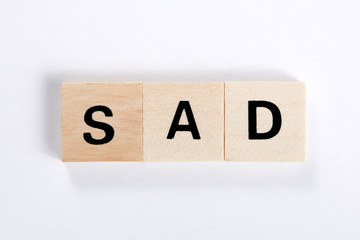 word sad made of wooden block isolated on white background