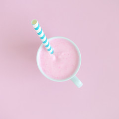 High angle view of cup of fruit smoothie on rose background.