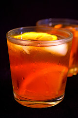 Iced tea with lemon and orange. Refreshment. Black background