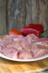 Raw kebab from meat on a wooden board with vegetables
